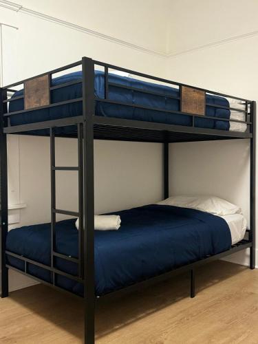 a bunk bed with a blue bed in a room at Green House in Los Angeles
