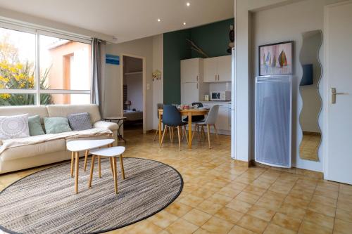 un salon avec un canapé et une table et une cuisine dans l'établissement jolie maison avec jardin la pironniere 6 personnes, à Les Sables-dʼOlonne