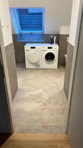 a washing machine in a bathroom with a window at Apartment Hof Düker, 2 Komfort DZ, Design Bad in Gütersloh