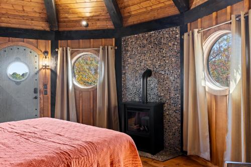a bedroom with a bed with a fireplace and two windows at Ancient Lore Village in Knoxville