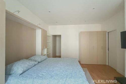 une chambre avec un grand lit avec une couverture bleue dans l'établissement Flexliving - Dardanelles - Studio, à Paris