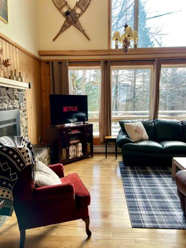 a living room with a couch and a tv at Cozy Chalet at Jay Peak in Montgomery Center