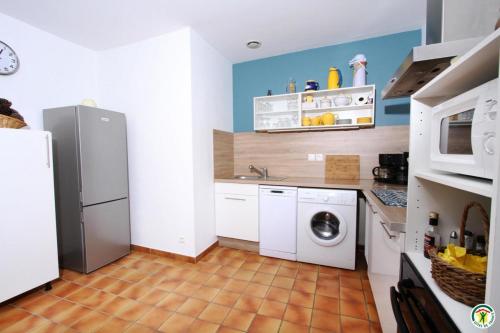 a kitchen with a refrigerator and a washing machine at Gite le Sagnac 4 personnes in Sauzet