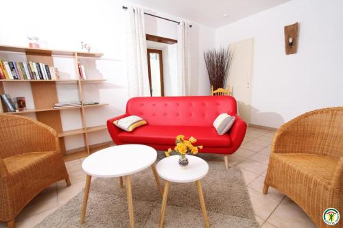 a living room with a red couch and two chairs at Gite le Sagnac 4 personnes in Sauzet