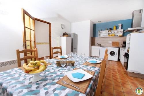 a kitchen with a table with a bowl of bananas on it at Gite le Sagnac 4 personnes in Sauzet