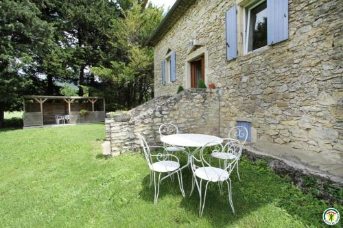 a table and chairs in front of a stone building at Gite le Sagnac 4 personnes in Sauzet