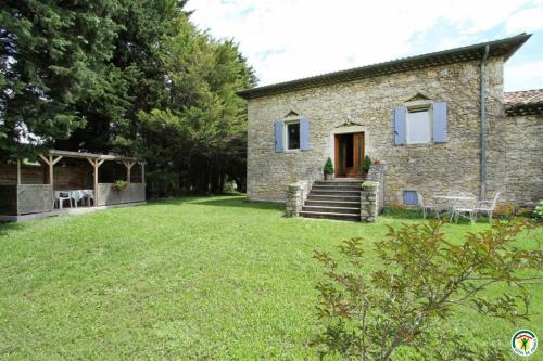 a stone house with a lawn in front of it at Gite le Sagnac 4 personnes in Sauzet