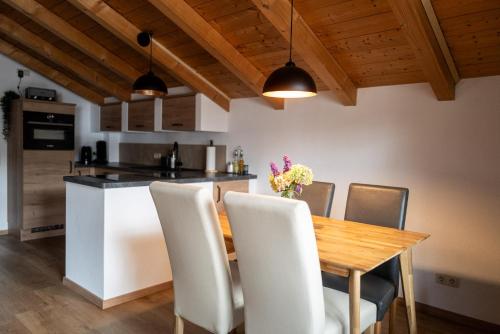 a kitchen and dining room with a wooden table and chairs at Achentaler Alpentor in Marquartstein