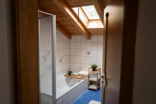 a bathroom with a bath tub and a skylight at Achentaler Alpentor in Marquartstein