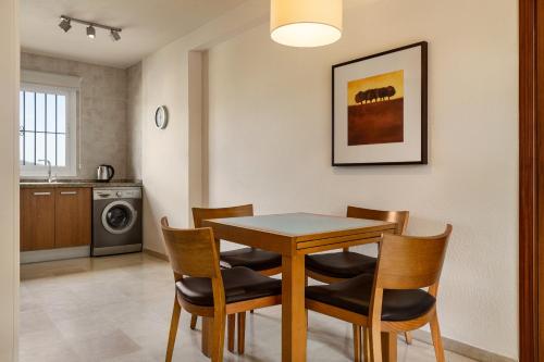 a kitchen and dining room with a table and chairs at Ramada Hotel & Suites by Wyndham Costa del Sol in Fuengirola