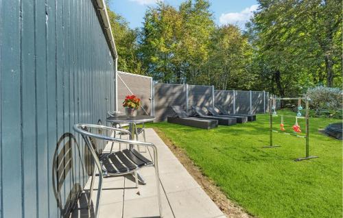 a patio with a table and chairs next to a fence at Beautiful Home In Varde With Kitchen in Varde