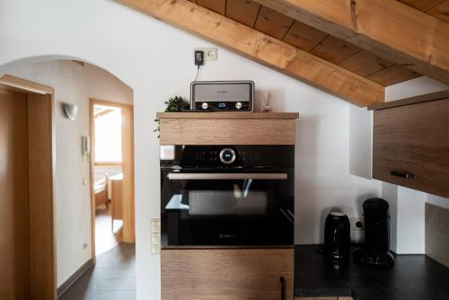 a kitchen with a microwave and a stove at Achentaler Alpentor in Marquartstein
