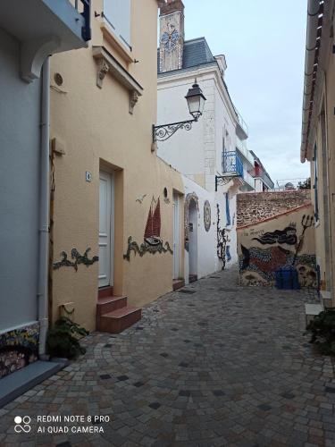 Une allée avec des peintures sur le côté des bâtiments dans l'établissement Studio centre ville, à Les Sables-dʼOlonne