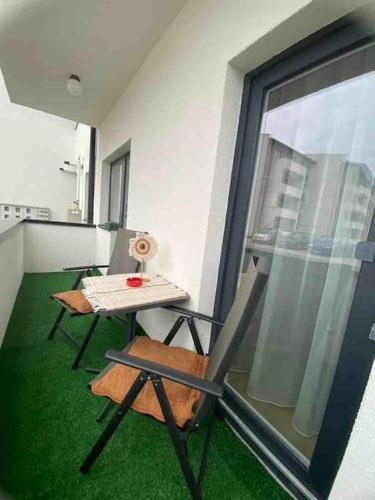 a room with a table and a chair and a window at Malina Residence Aparthotel in Cisnădie
