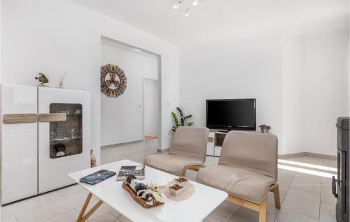 a living room with two chairs and a table and a tv at Stunning Home In Lun With Wifi in Lun