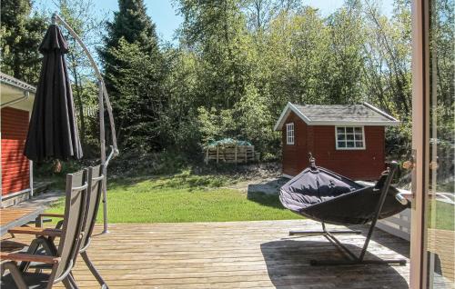 a patio with a hammock and an umbrella on a deck at Amazing Home In Nexø With Wifi in Neksø