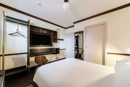 a hotel room with a bed and a tv at Jefferson Hotel in Miami
