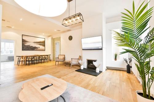 a living room with a table and a fireplace at Wonderful Fitzrovia 3 Bed Apartment in London