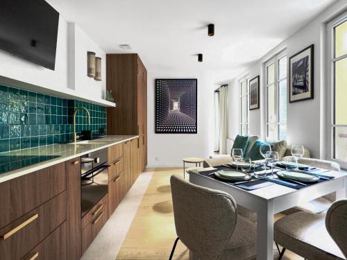 une cuisine et une salle à manger avec une table et des chaises dans l'établissement Charmant appartement 4P - Arc de Triomphe 17eme, à Paris