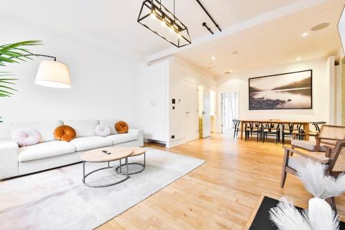 a living room with a white couch and a table at Wonderful Fitzrovia 3 Bed Apartment in London