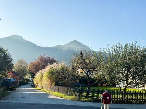 a person riding a bike down a street with a mountain at Achentaler Alpentor in Marquartstein