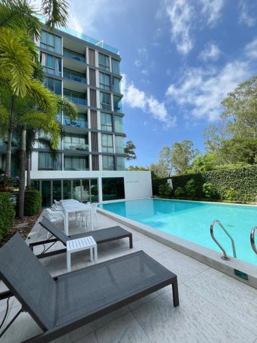 a swimming pool in front of a building at Oceanstone Condo 2 bedrooms BangTao Laguna in Bang Tao Beach