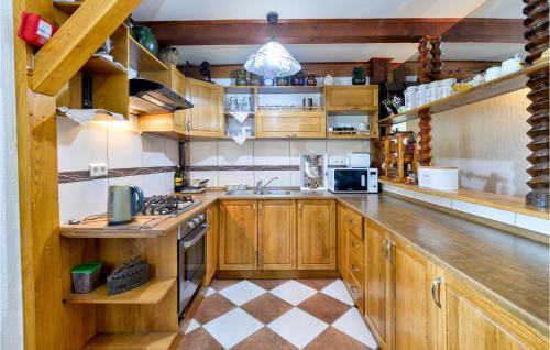 a kitchen with wooden cabinets and a stove top oven at Beautiful Home In Bedenica With Wifi in Bedenica