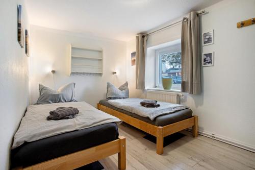 Un dormitorio con dos camas y una ventana. en Bäckerhus - Ferienwohnung 2, en Wiek auf Rügen