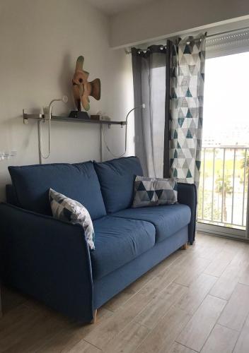 - un canapé bleu dans le salon dans l'établissement Studio direct plage, au Lavandou