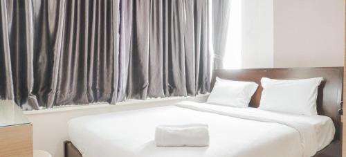 a bedroom with two beds with white sheets and pillows at Stunning Comfy Condominium High Floor at the Heart of Central Jakarta in Jakarta