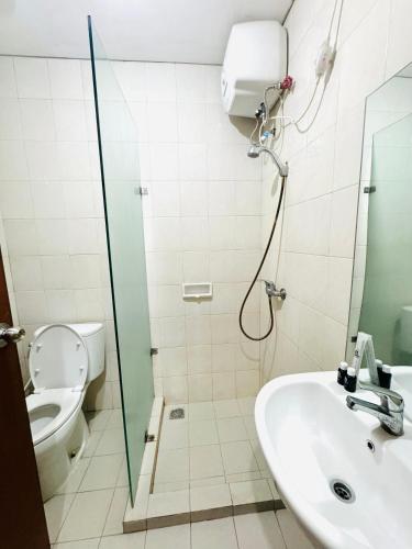 a bathroom with a shower and a toilet and a sink at Stunning Comfy Condominium High Floor at the Heart of Central Jakarta in Jakarta