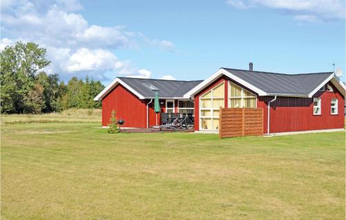 a red barn with a black roof on a field at Holiday Home Kuskevej Jerup Iv in Jerup