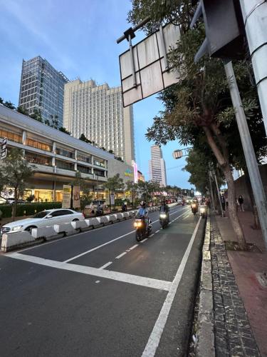 a group of motorcycles driving down a city street at Stunning Comfy Condominium High Floor at the Heart of Central Jakarta in Jakarta