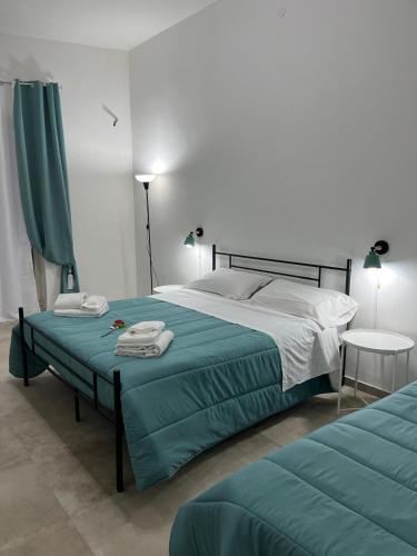 a bedroom with a large bed with a green blanket at Falaride suite Agrigento discesa sulla valle di oro in Agrigento