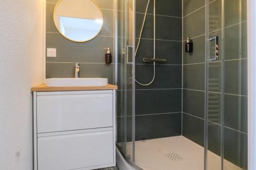 une salle de bain avec une douche avec un lavabo et un miroir dans l'établissement Studio rénové face au Port Olona Les Sables d'Olonne - 4 personnes, à Les Sables-dʼOlonne