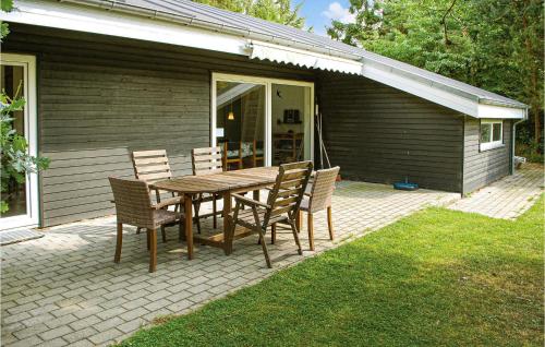 a wooden table and chairs on a patio at Holiday Home Eneb in Dagstrup