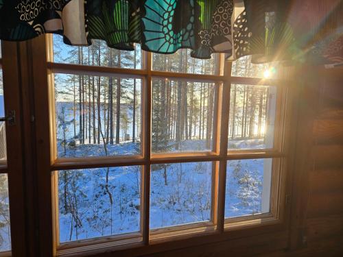 a window with a view of a snow covered forest at Vernetti 1 Koli in Kolinkylä