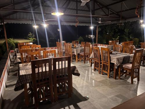 a dining room with tables and chairs and lights at WOW STAYZ2 Pachmarhi Foothill Cottages in Pachmarhī