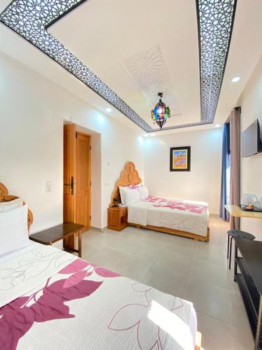 a bedroom with two beds and a couch in it at Dar Syraya in Chefchaouene