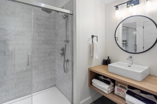 a bathroom with a shower and a sink and a mirror at Parc Omega in Montebello