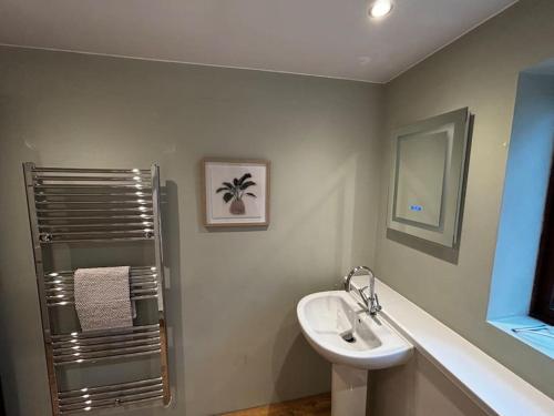 a white bathroom with a sink and a mirror at Dovera, private parking included, Bowness on Windermere in Bowness-on-Windermere