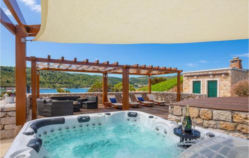 an outdoor hot tub on a patio with a pergola at Nice Home In Vis With Kitchen in Vis