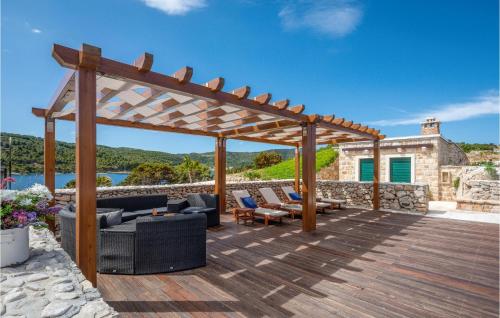 a wooden deck with a pergola and furniture at Nice Home In Vis With Kitchen in Vis