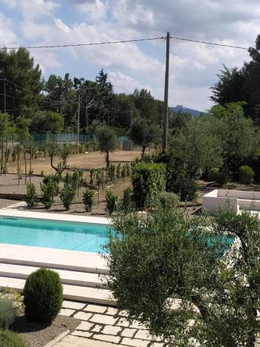 a swimming pool in a garden with trees at I MURETTI A SECCO B&B in Castel del Monte