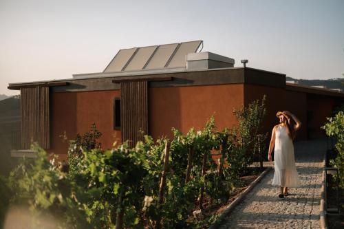 a woman in a white dress walking in front of a building at Casa do Romezal in Peso da Régua