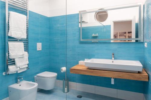 a blue bathroom with a sink and a toilet at Tenuta D'Amore in San Mango Piemonte
