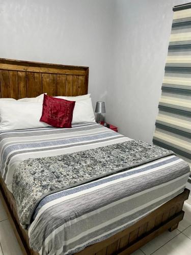 a bed with a red pillow on top of it at SapzRes at Klerksdorp in Klerksdorp
