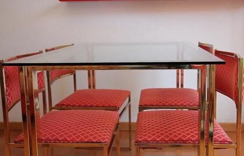 a table and two chairs with red cushions under it at Pràti Home in Rome