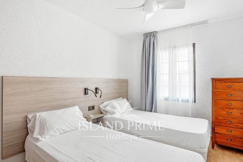 a bedroom with two beds and a dresser and a window at 2x bedrooms Heated Pool Holiday in Amarilla Golf FC2613-2xE in San Miguel de Abona