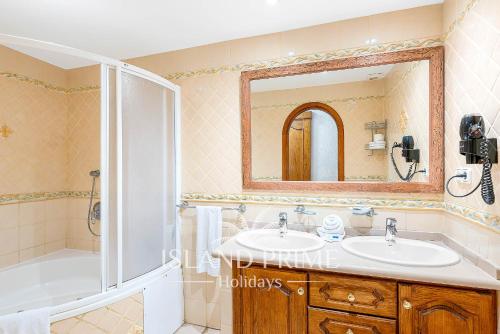 a bathroom with a sink and a tub and a mirror at 2x bedrooms Heated Pool Holiday in Amarilla Golf FC2613-2xE in San Miguel de Abona